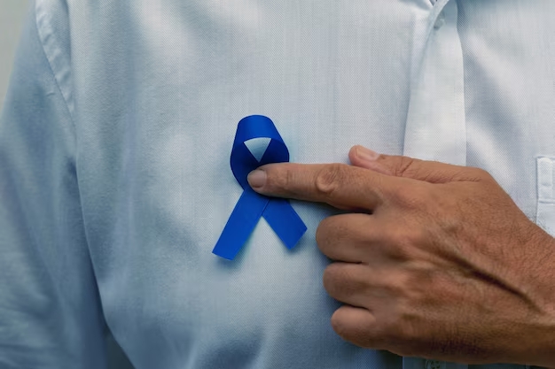 Homem de meia idade segurando fita azul sobre o peito.